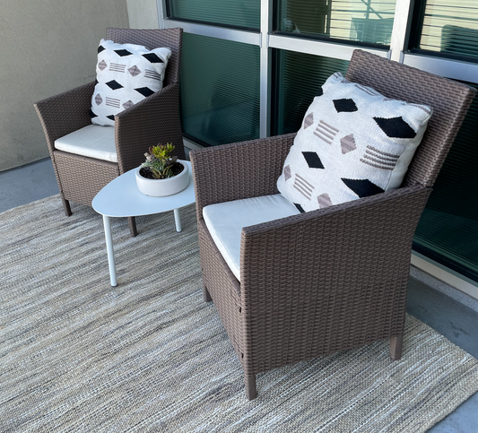Brown woven resin outdoor chair with cream cushion