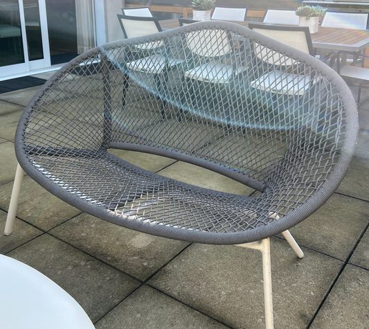 Gray woven outdoor love seat with white metal frame