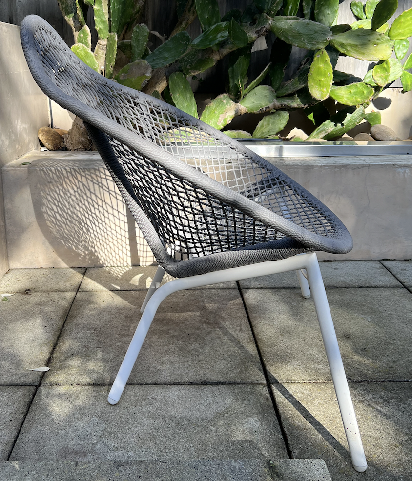 Gray woven outdoor chair with white metal frame