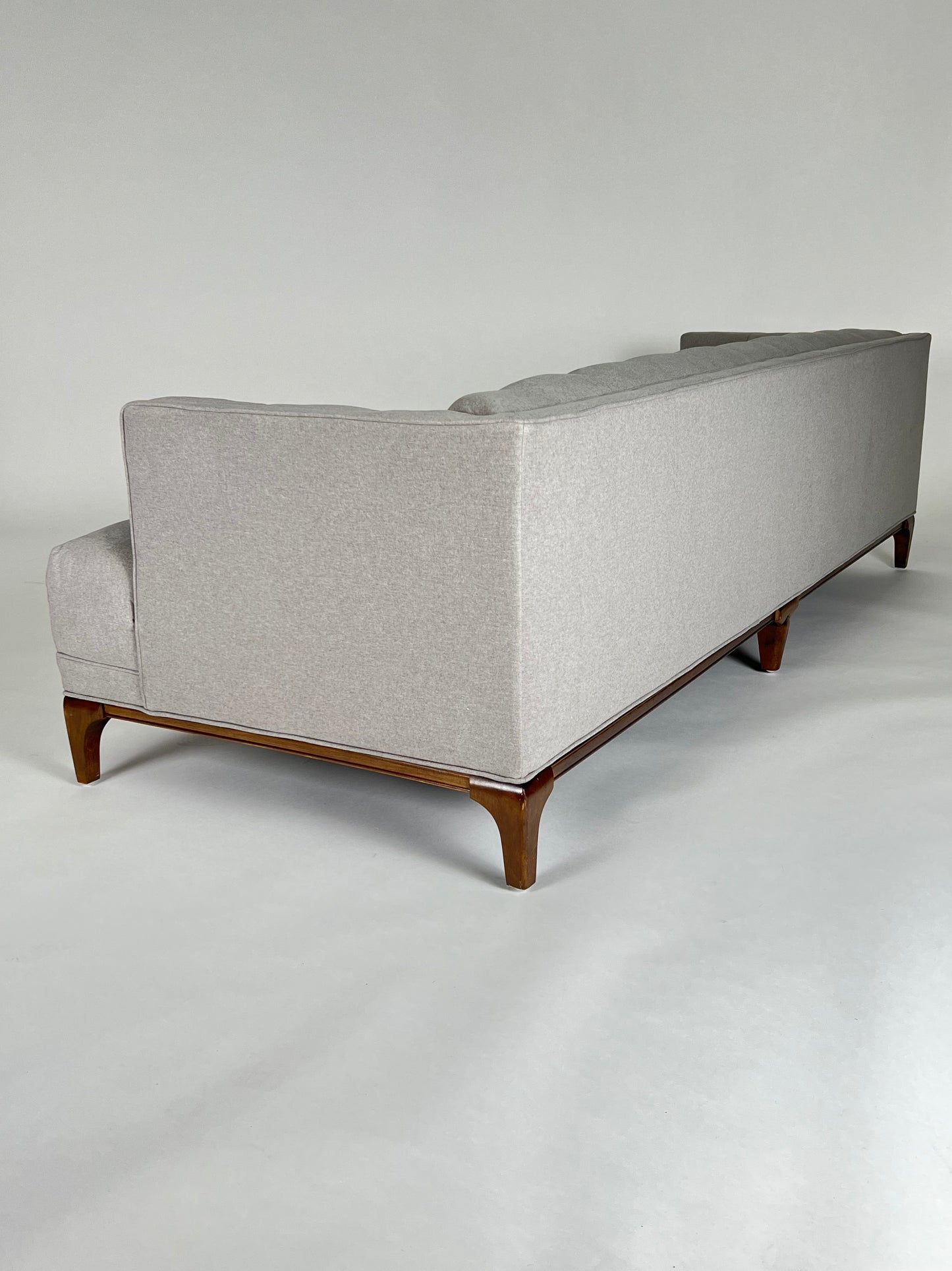 Soft gray sofa, blind tufting, walnut frame and legs, mid-century styling