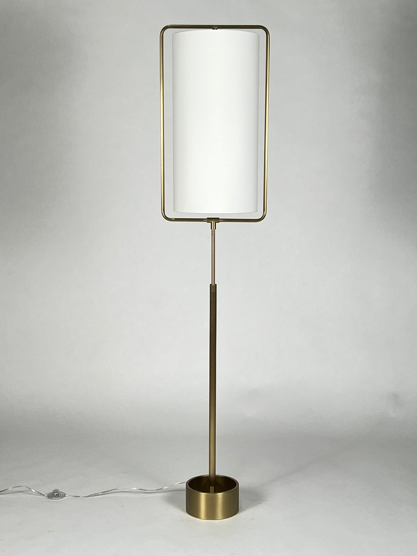 Brass floor lamp with tall round white shade