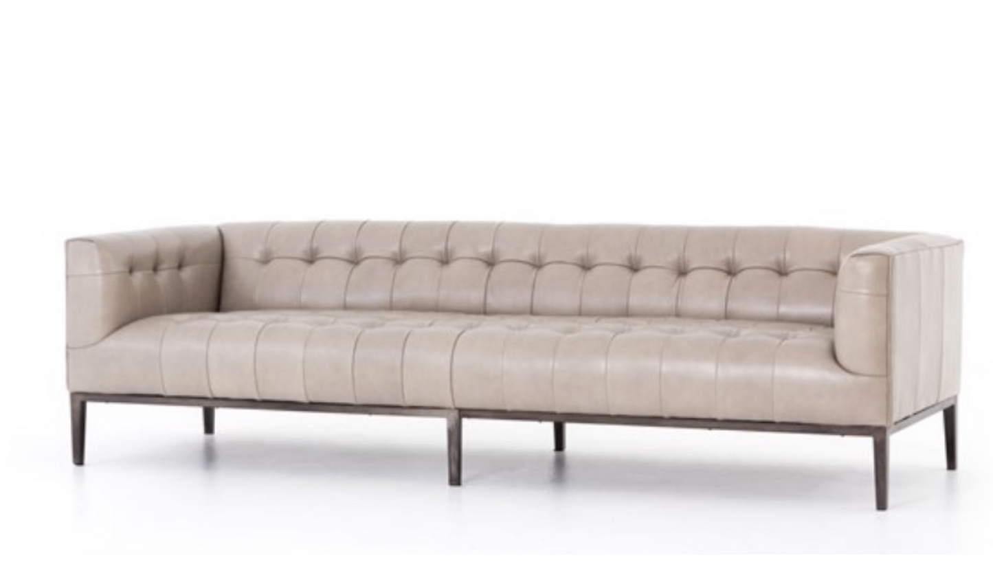 Buff colored leather sofa, squared off arms, blind tufting, gunmetal toned legs