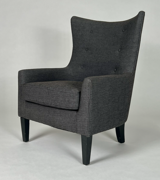 Modern dark charcoal fabric wing back chair, with black tapered legs