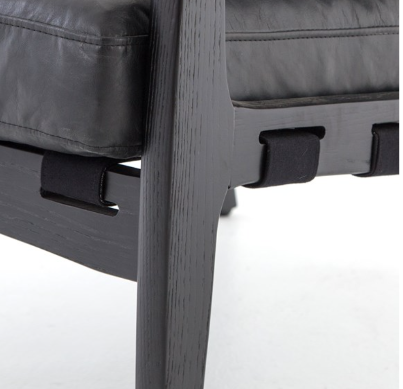 Black hand finished leather chair with black wood frame. Back has strapping made of canvas, leather and buckles