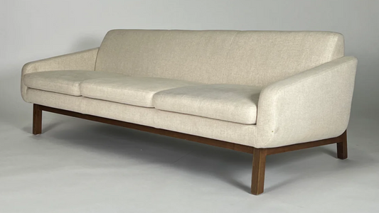 Cream sofa with wood frame, wood back legs, mid-century styling