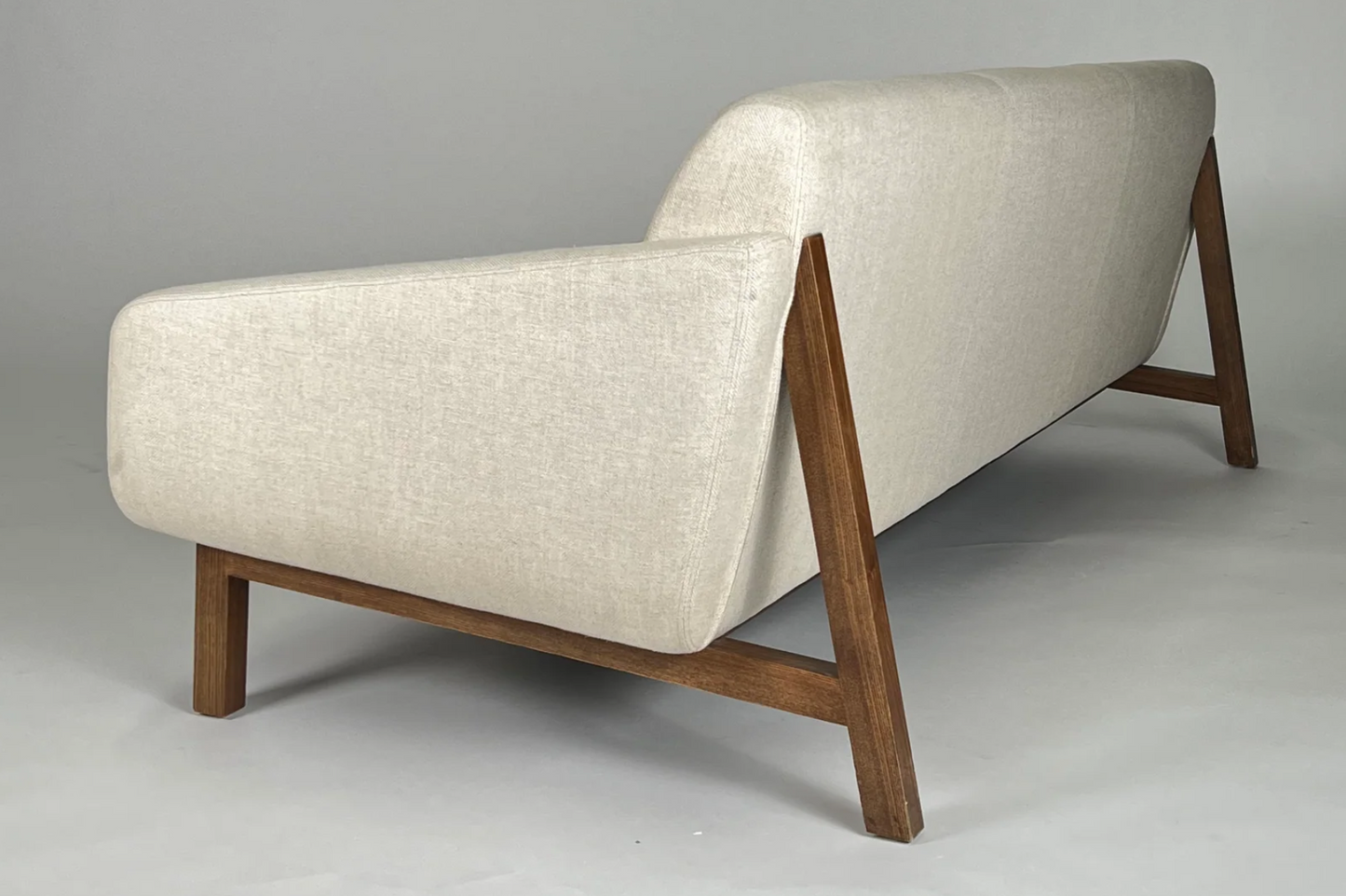 Cream sofa with wood frame, wood back legs, mid-century styling