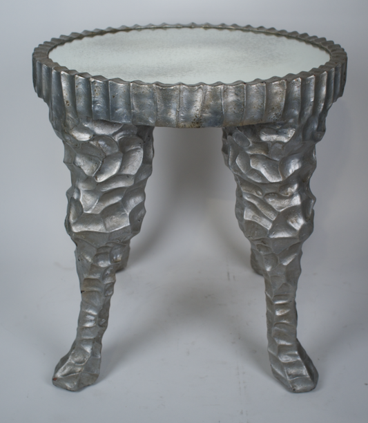 Matte silver resin sculpted side table with round antique mirror top
