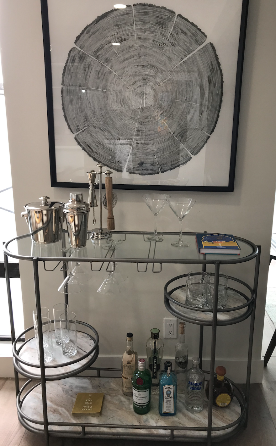 Bar cart with staggered marble and glass shelving, iron framework