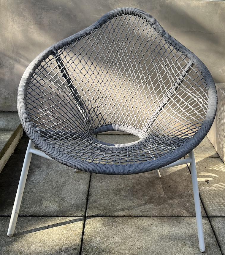 Gray woven outdoor chair with white metal frame