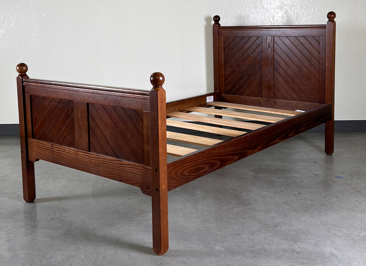 Brown wood twin bed with finials