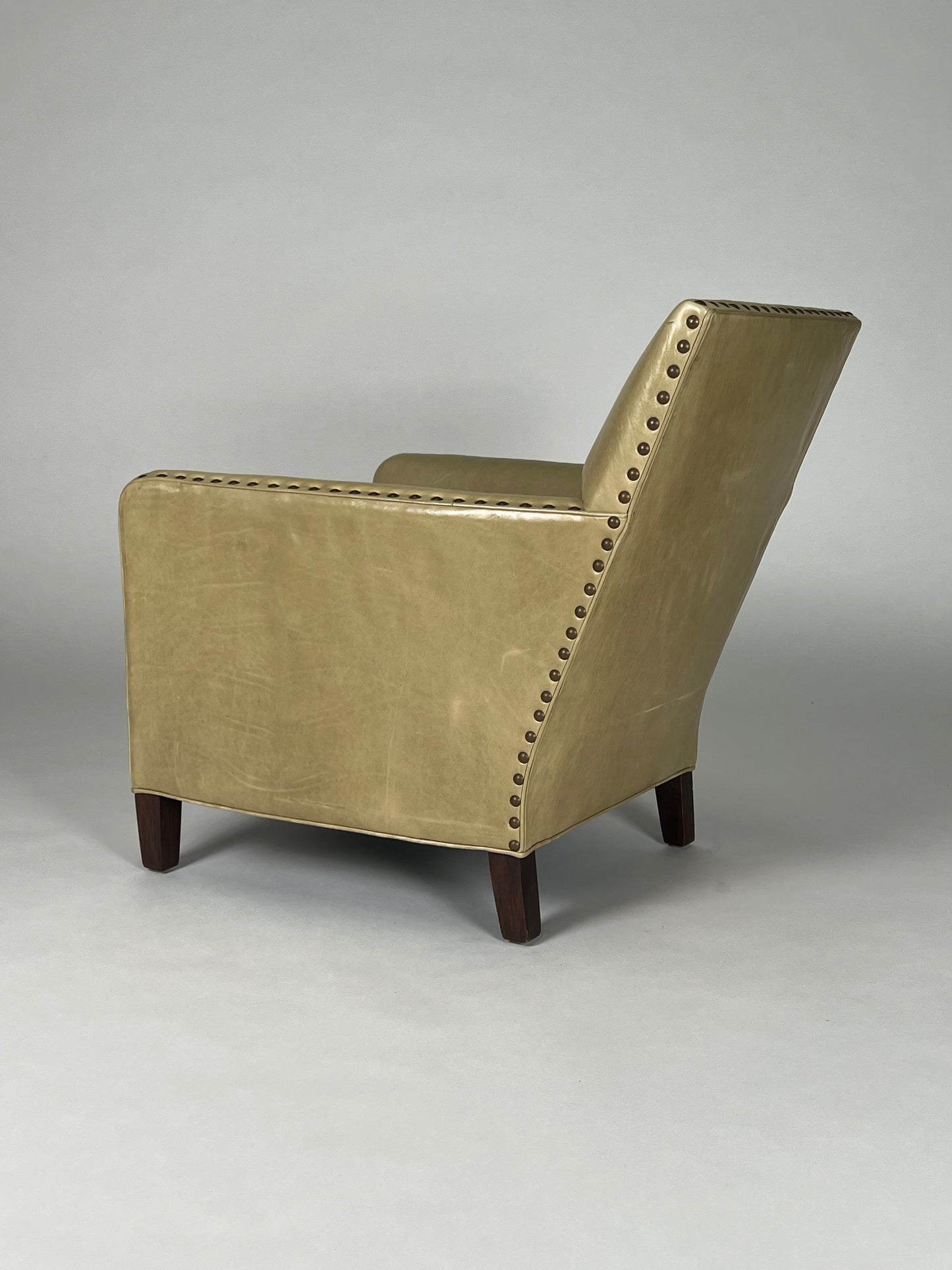 Parchment colored leather chair with nailhead trim