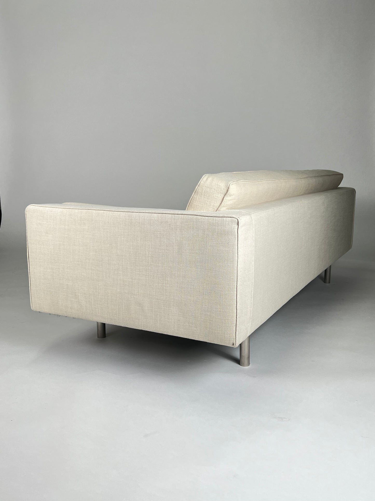 Cream tight back sofa with 2 bolsters, chrome legs