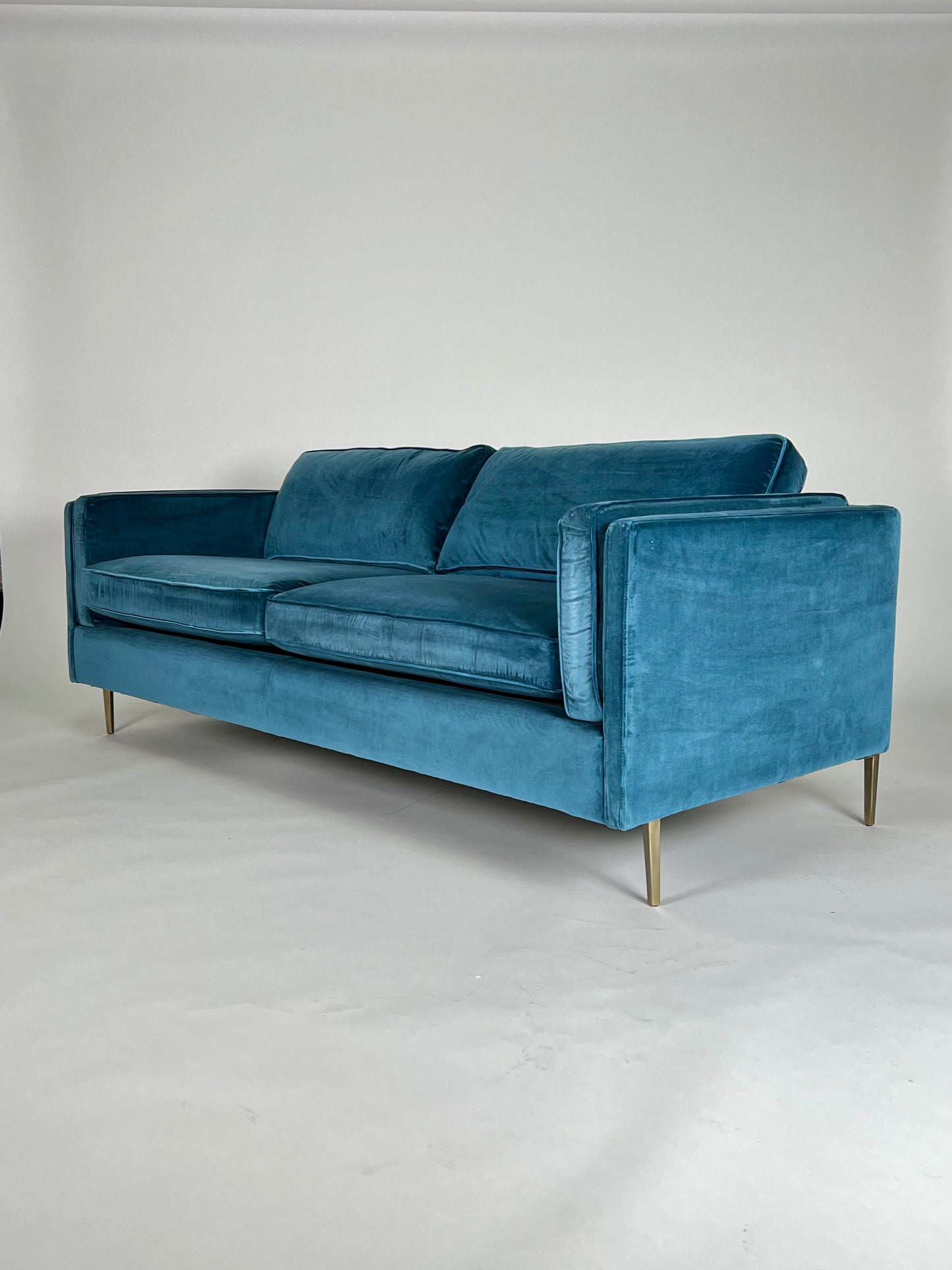 Sapphire / teal blue velvet sofa with brass legs, mid-century styling