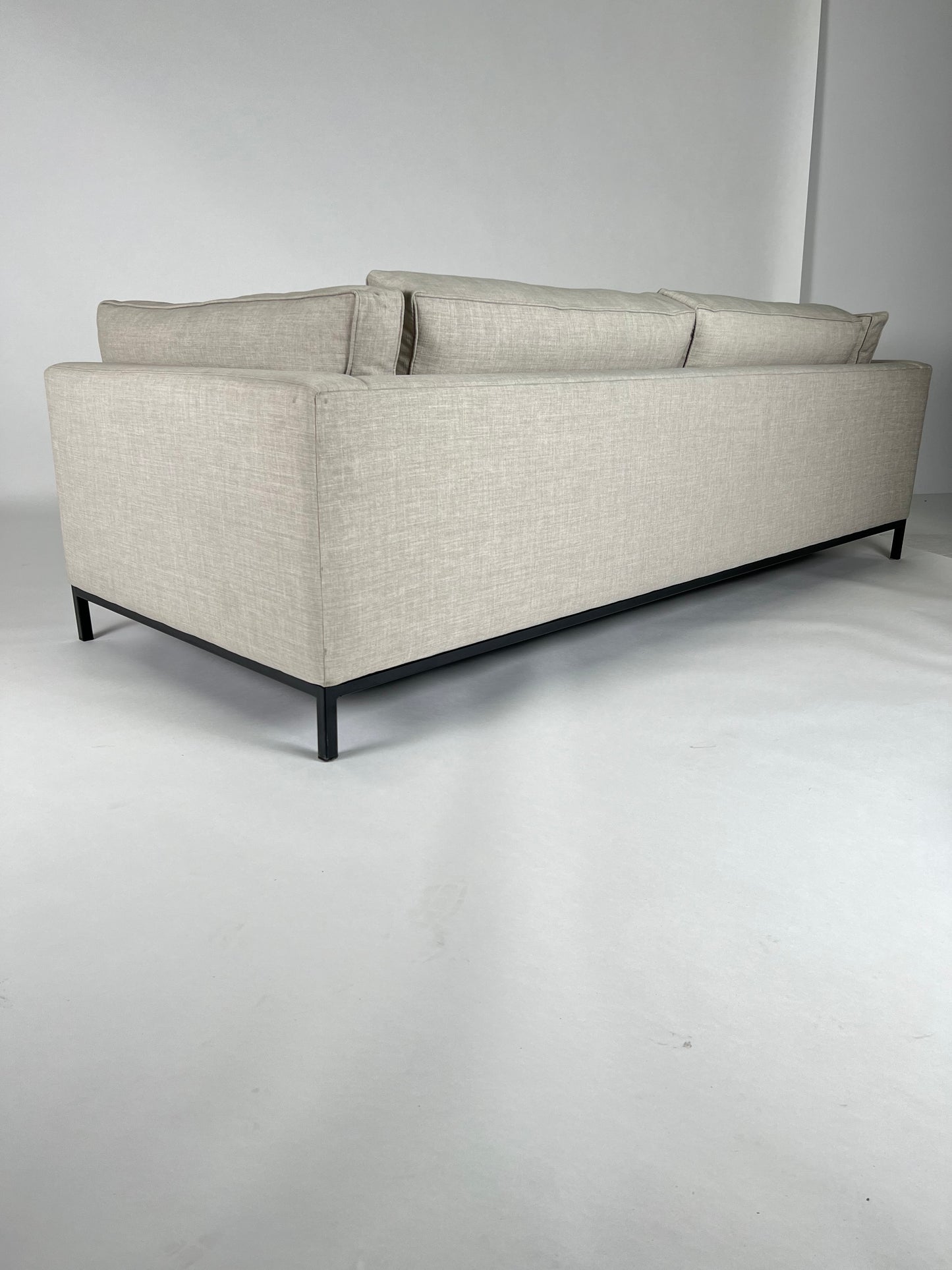 Light gray fabric sofa with simple black iron base