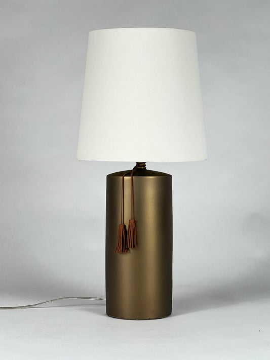 Brass colored ceramic table lamp with leather tassel