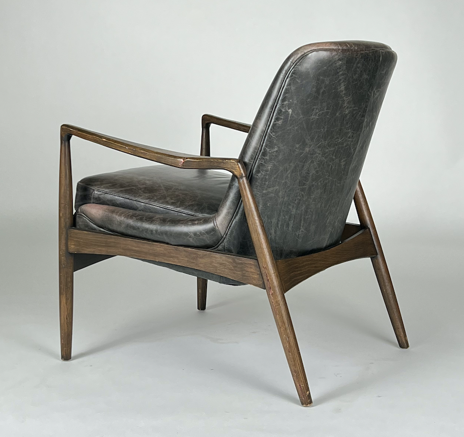 Dark smoke leather chair with sculpted wood arms and frame