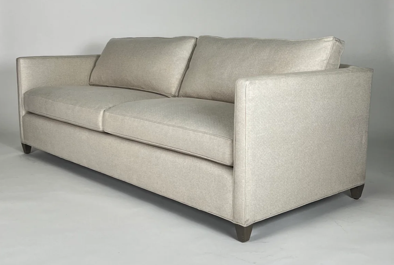 Cream sofa, thin arms, dark wood legs