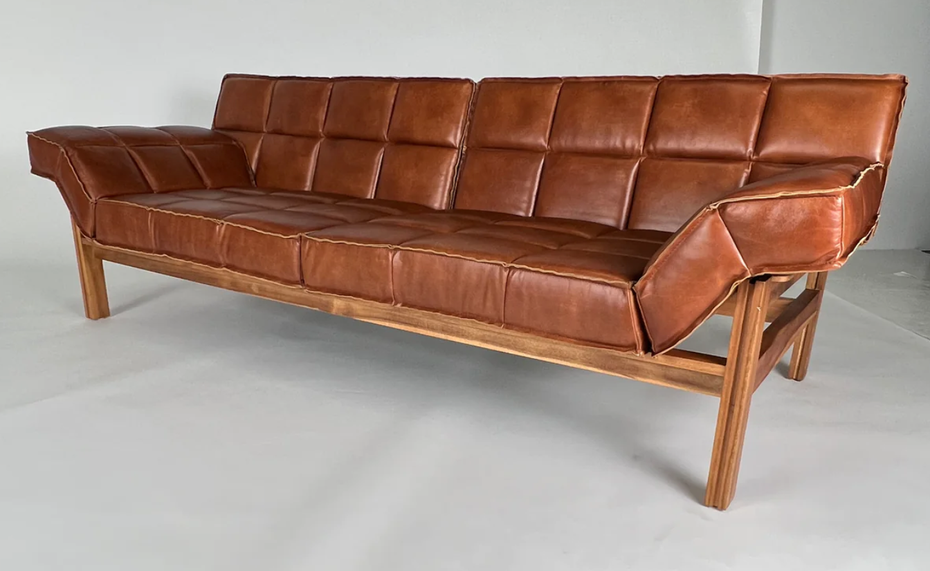 Brown leather channeled sofa, sling back, brown wood frame. 