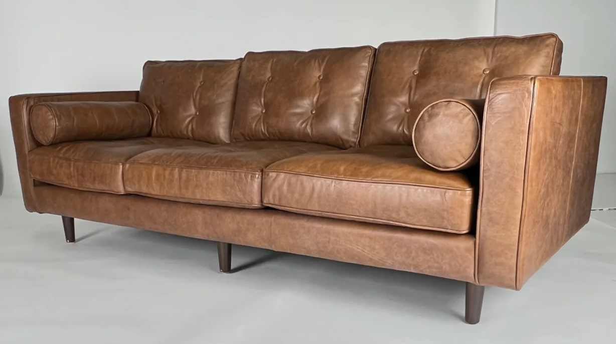 Brown leather sofa with bolsters