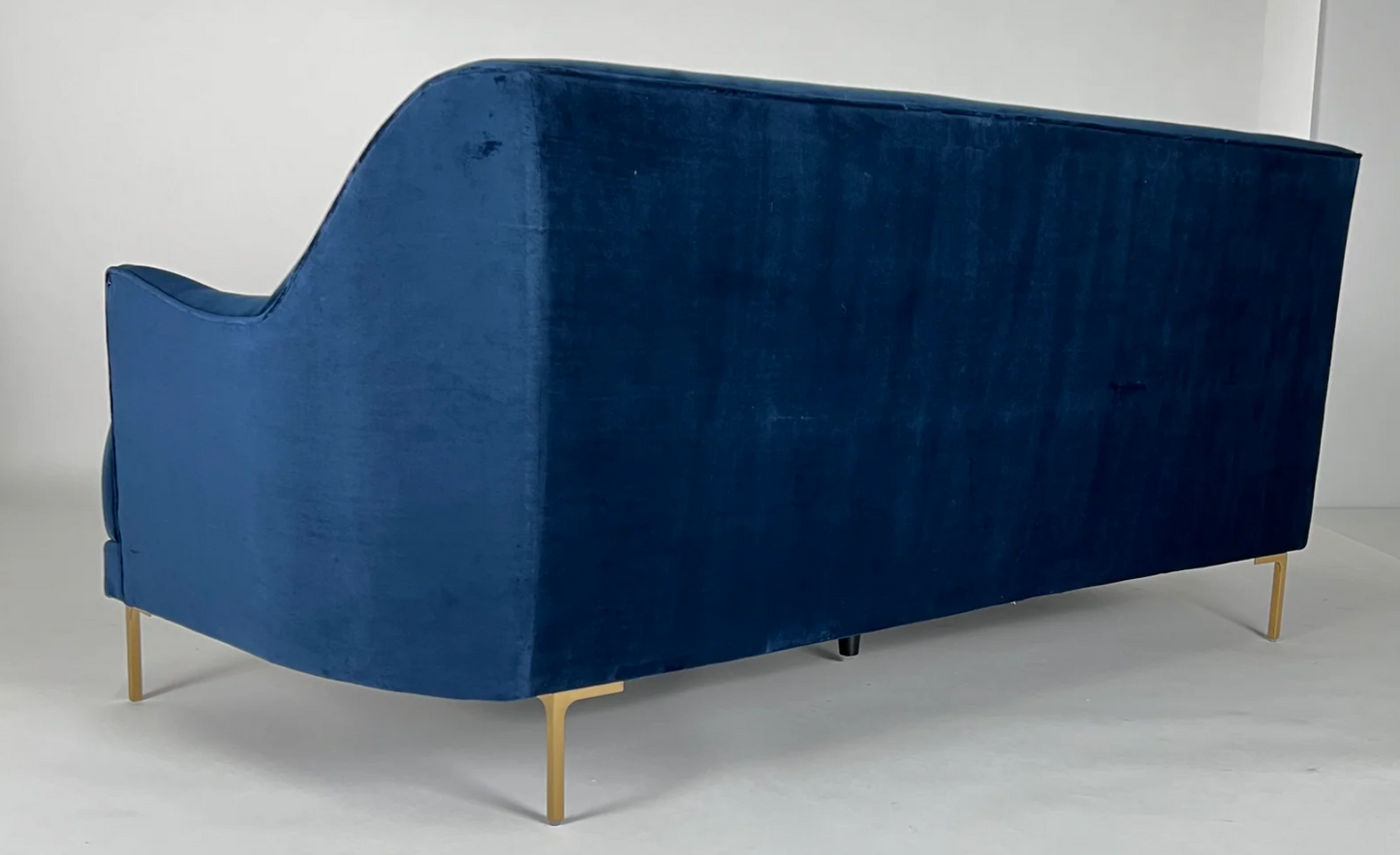 Blue velvet sofa with curved back, brass legs