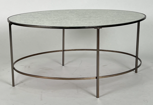 Oval coffee table with antique mirrored top, dark brass frame