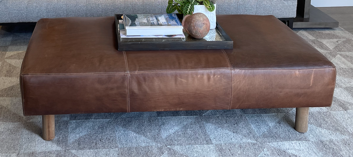 Brown leather coffee table or bench with round nude wood legs