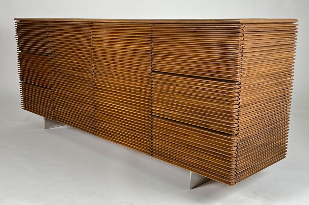 Horizontal detail on brown wood buffet or dresser, slab chrome legs