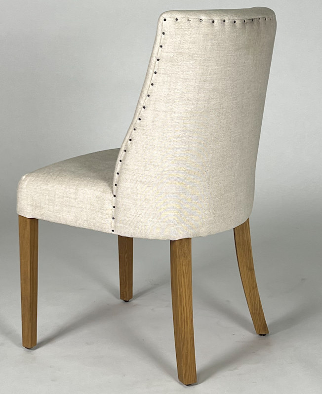 Cream upholstered barrel back dining chair with nailhead trim, brown legs