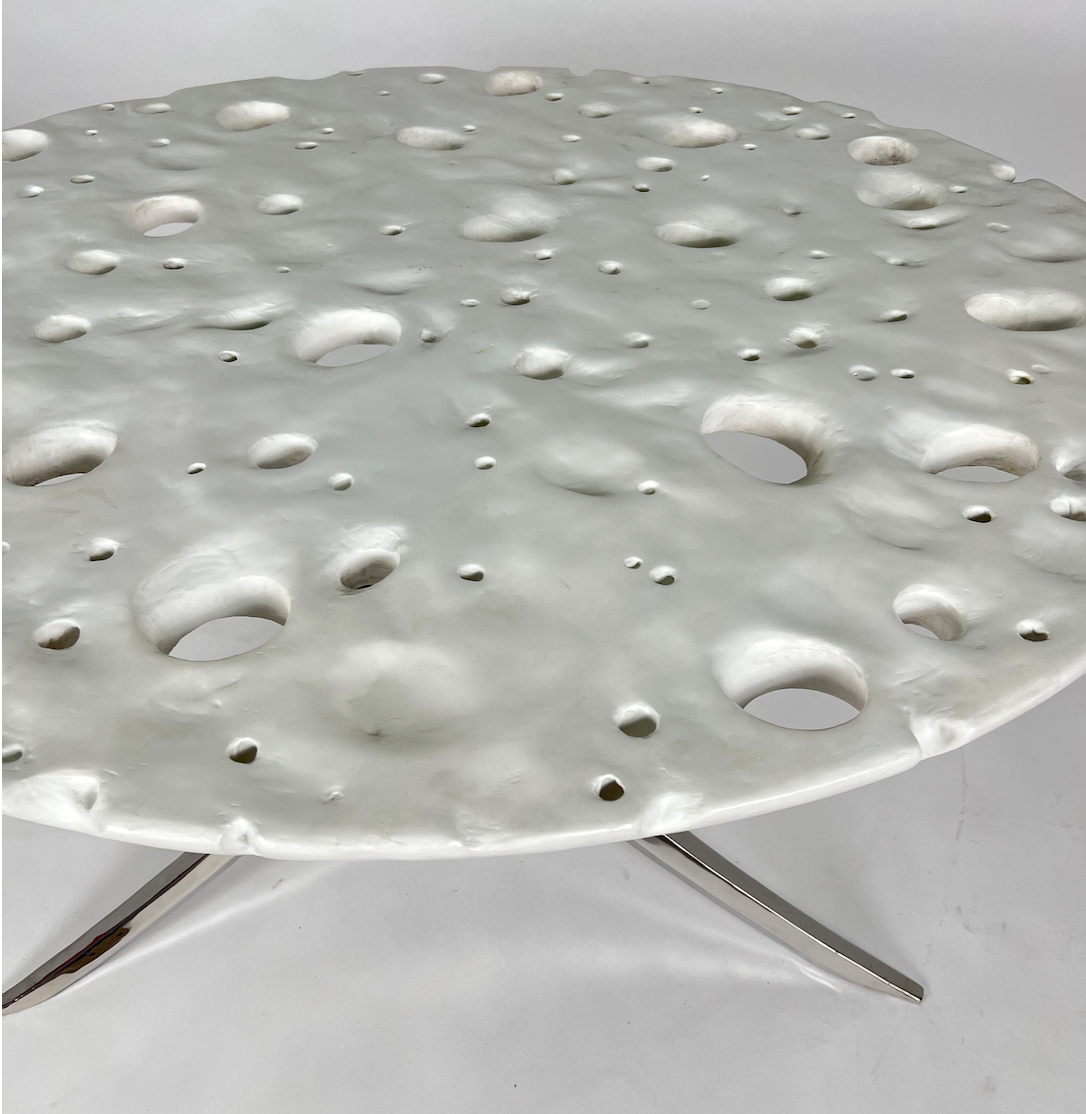 Round white Swiss cheese moon table with chrome 3 legged base