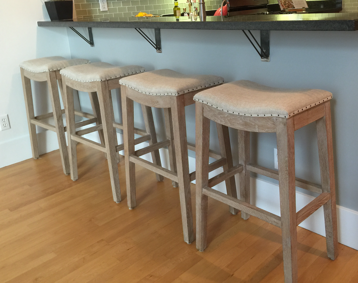 White washed wood bar stool with linen seat, nailhead trim