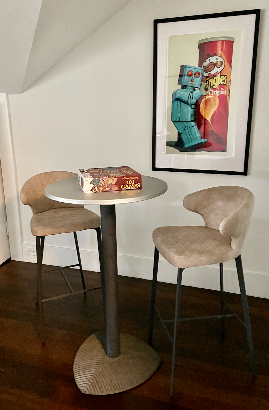 Bar stool with back, tan upholstery, dark metal legs